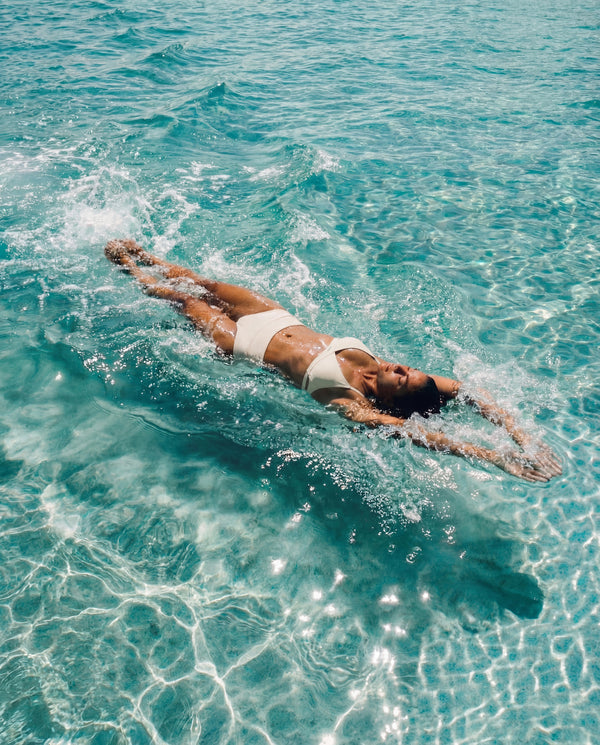 Woman lying on her stomach in clear blue water