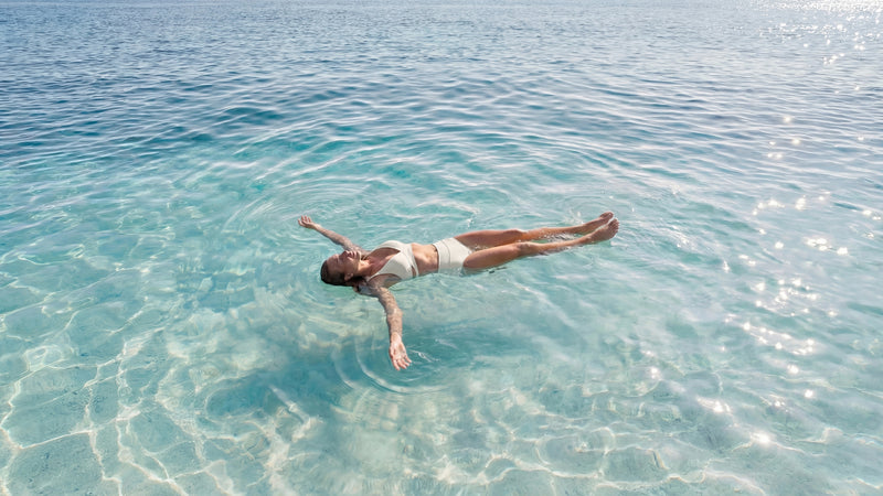 Person floating in clear blue water