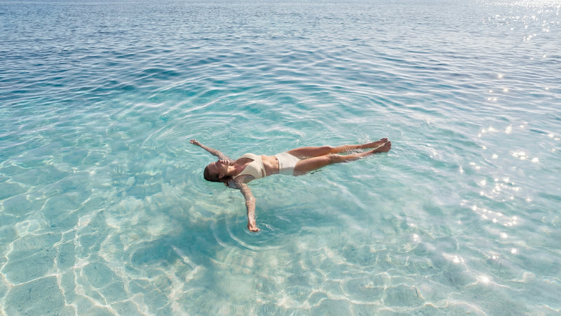 Person floating in clear blue water