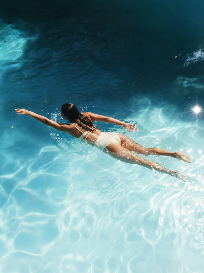 Person swimming in a clear blue pool